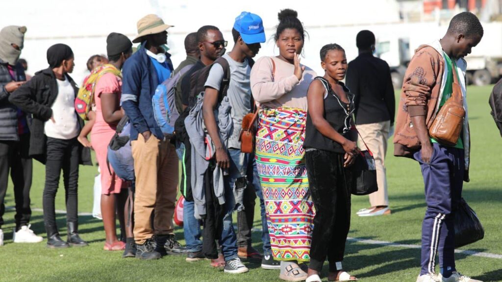Stranded Malawian migrants wait for buses at Sherwood Park camp